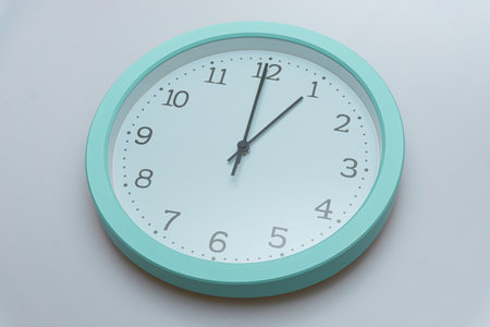 Wall clock showing various times on a white backgroundの写真素材