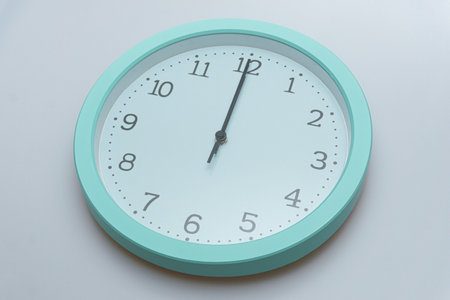 Wall clock showing various times on a white backgroundの写真素材