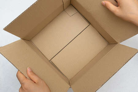 Unboxing the courier box with a cutter knifeの写真素材
