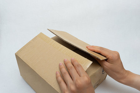 Unboxing the courier box with a cutter knifeの写真素材