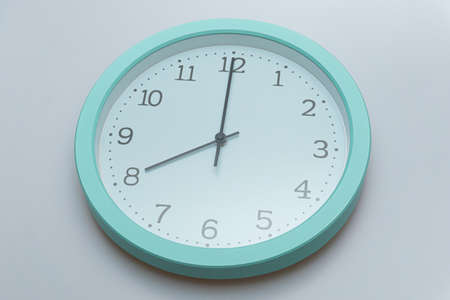 Wall clock showing various times on a white backgroundの写真素材