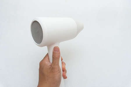 A woman drying her hair with a hair dryerの写真素材