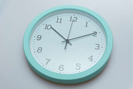 Wall clock showing various times on a white backgroundの写真素材
