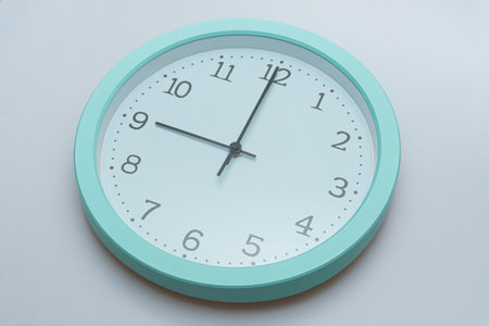 Wall clock showing various times on a white backgroundの写真素材