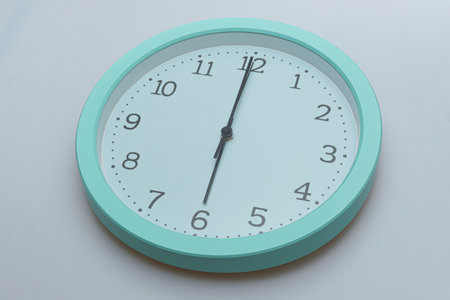 Wall clock showing various times on a white backgroundの写真素材