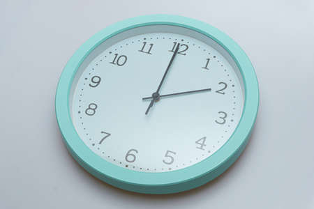 Wall clock showing various times on a white backgroundの写真素材