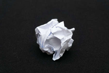 A mess of crumpled paper trash on a black backgroundの写真素材