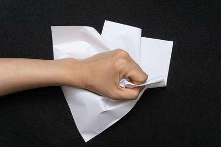 A mess of crumpled paper trash on a black backgroundの写真素材