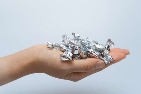 Hands full of candies in silver shells