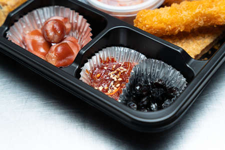 A delicious-looking lunch box with a variety of side dishes, fruits and tempuraの写真素材