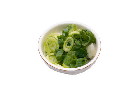 Green onion being trimmed on a white backgroundの写真素材