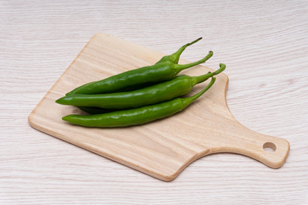 Fresh green chillies plated on a white backgroundの写真素材