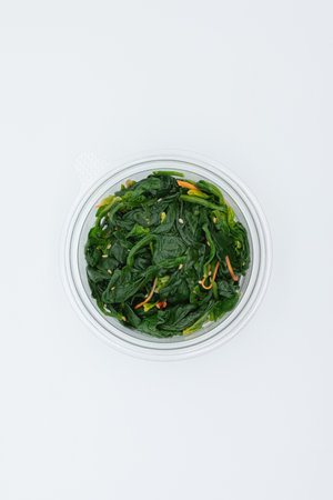 Bowl of stir-fried spinach isolated on a white background.の写真素材