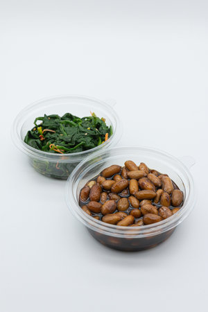 Chinese food, Stir-fried beans and spinach in plastic container on white backgroundの写真素材