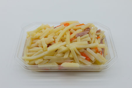 Fried potatoes in a plastic box on a white isolated background.の写真素材