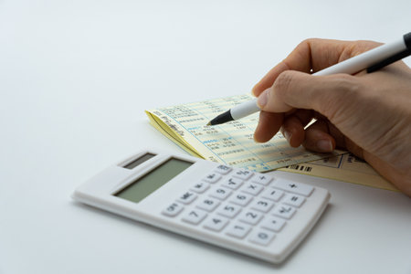 Businessman using calculator to calculate numbers on white background with copy space.の写真素材