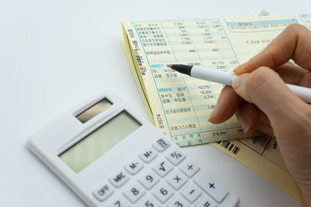 Calculator and pen with financial statement on white background, business conceptの写真素材