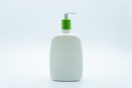 White plastic bottle with green liquid soap dispenser isolated on white backgroundの写真素材