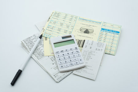 Calculator, pen and financial documents on a white background.の写真素材
