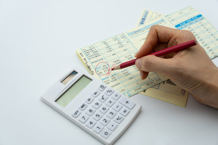Close-up of female hand using a calculator and filling tax formの写真素材