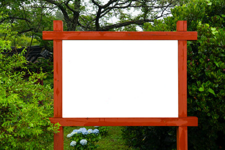 Blank white signboard in the garden with green leaves background.の写真素材