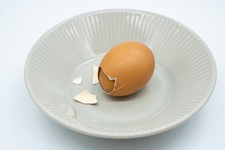 Broken egg in a plate on a white background. Isolatedの写真素材