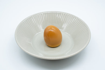 Egg in a white saucer on a white background, isolateの写真素材