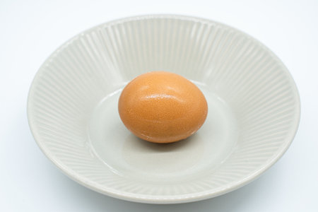 Egg in a white plate on a white background, isolate.の写真素材
