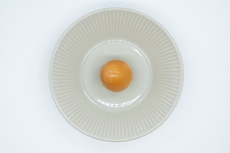 egg yolk in a white plate on a white background, top viewの写真素材