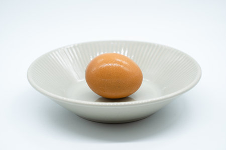 Eggs in the white bowl isolated on the white background.の写真素材