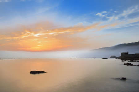 Sunset by the sea and mistの写真素材