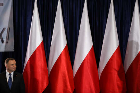 Wloszczowa, Poland - 06 February 2020: portrait of the Polish President Andrzej Duda on the background of Polish white and red flags, at the meeting with votersのeditorial素材