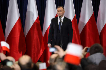 Wloszczowa, Poland - 06 February 2020: portrait of the Polish President Andrzej Duda on the background of Polish white and red flags, at the meeting with votersのeditorial素材