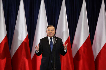 Wloszczowa, Poland - 06 February 2020: portrait of the Polish President Andrzej Duda on the background of Polish white and red flags, at the meeting with votersのeditorial素材