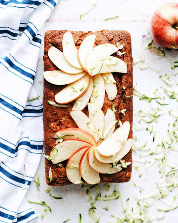 Overhead shot of a loaf of apple zucchini bread with decorative apple slices on top.