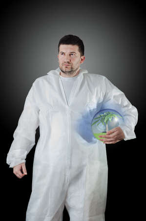 Young male in protective suit hold glass globe with tree and unpolluted air inside  He is concerned...