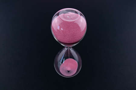 The concept of passing time, urgency and lack of time. Sand falls into the hourglass. The deadline...