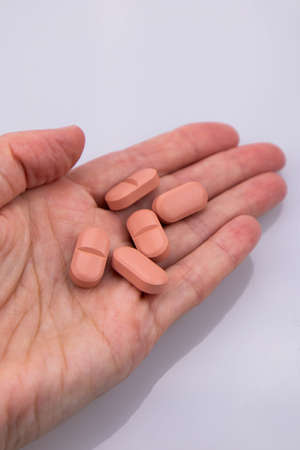 pink pharmaceutical medicine pills lie on the woman's hand. medicine for the disease. Close-up hand...