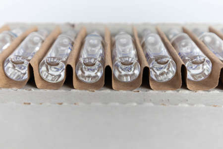 Transparent glass medical ampoules in cardboard packaging. Ampoules with medicine for injection