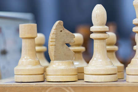 Playing wooden chess on a chessboard. Tactics and strategy. Black and white shapes.の写真素材