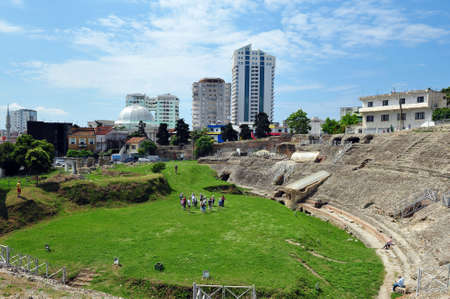 High angle view of amphi theatre in DÃ¼rres, Albania.  Tourists standing in a group with guide. Houses and tall buildingsin the background.の写真素材