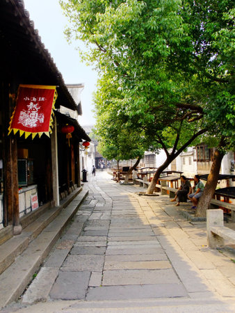 Wuzhen, China - September 5, 2011  Two women sitting and chatting under the trees in the street of Wuzhen,China のeditorial素材