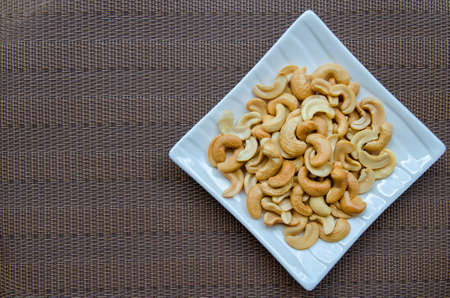 Cashew nuts in the plate on the table matの写真素材