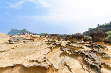 New Taipei City,Taiwan - March 15, 2015: Honeycomb weathering and mushroom rocks in Yehliu Geopark, Taiwan.People can seen exploring around it.のeditorial素材