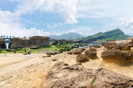 New Taipei City,Taiwan - March 15, 2015: Honeycomb weathering and honeycomb rocks in Yehliu Geopark, Taiwan.People can seen exploring around it.のeditorial素材
