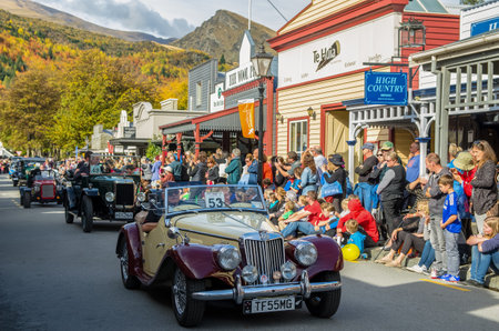 Arrowtown, New Zealand - April 23,2016 : There is a vintage cars parade event during the Arrowtown Autumn Festival on Buckingham Street, people can seen watching and enjoying the parade.のeditorial素材