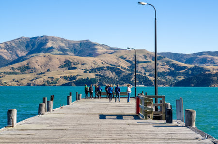 Akaroa,New Zealand - May 12,2016 : Jetty pier of Akaroa, south island of New Zealand. People can seen exploring around it.のeditorial素材
