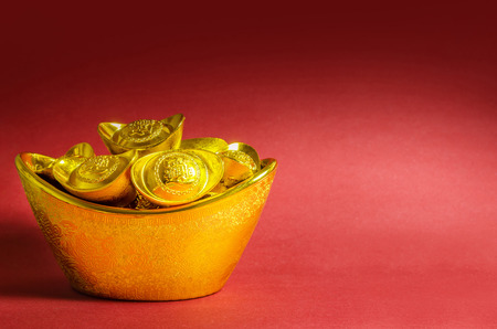 Chinese New Year gold ingots decorations on red background. (English translation for foreign text means blessing).の写真素材