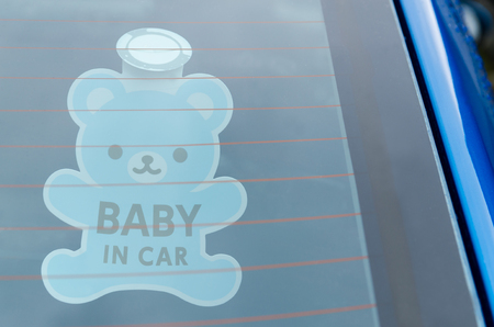 Close up of the baby in car board sign on the car back glass.の写真素材