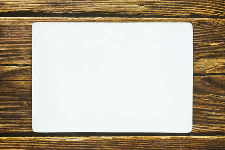 A rectangle empty white plate on the rustic wooden floor.